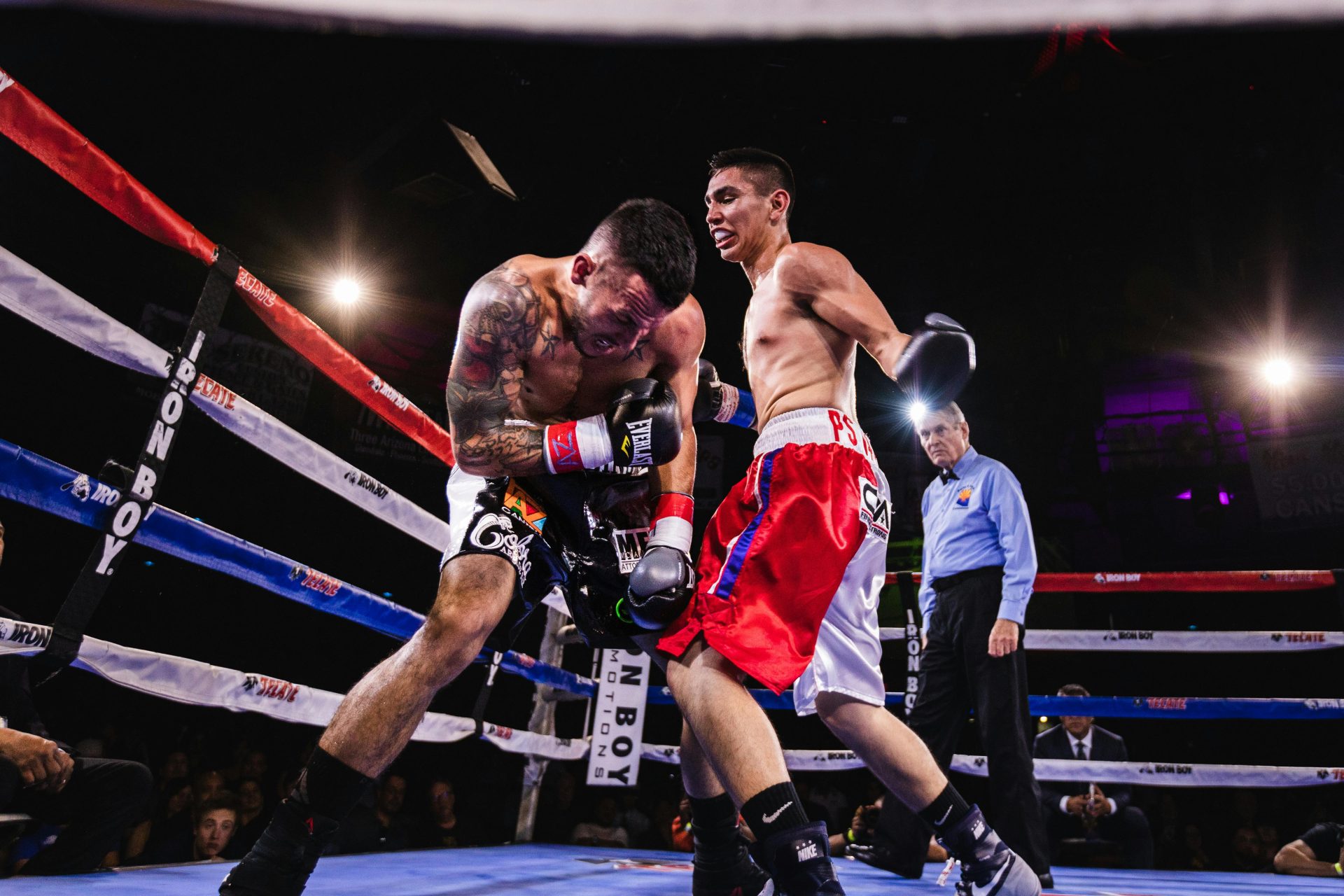 Una escena dinámica de dos boxeadores en acción durante un feroz combate en el ring de boxeo.